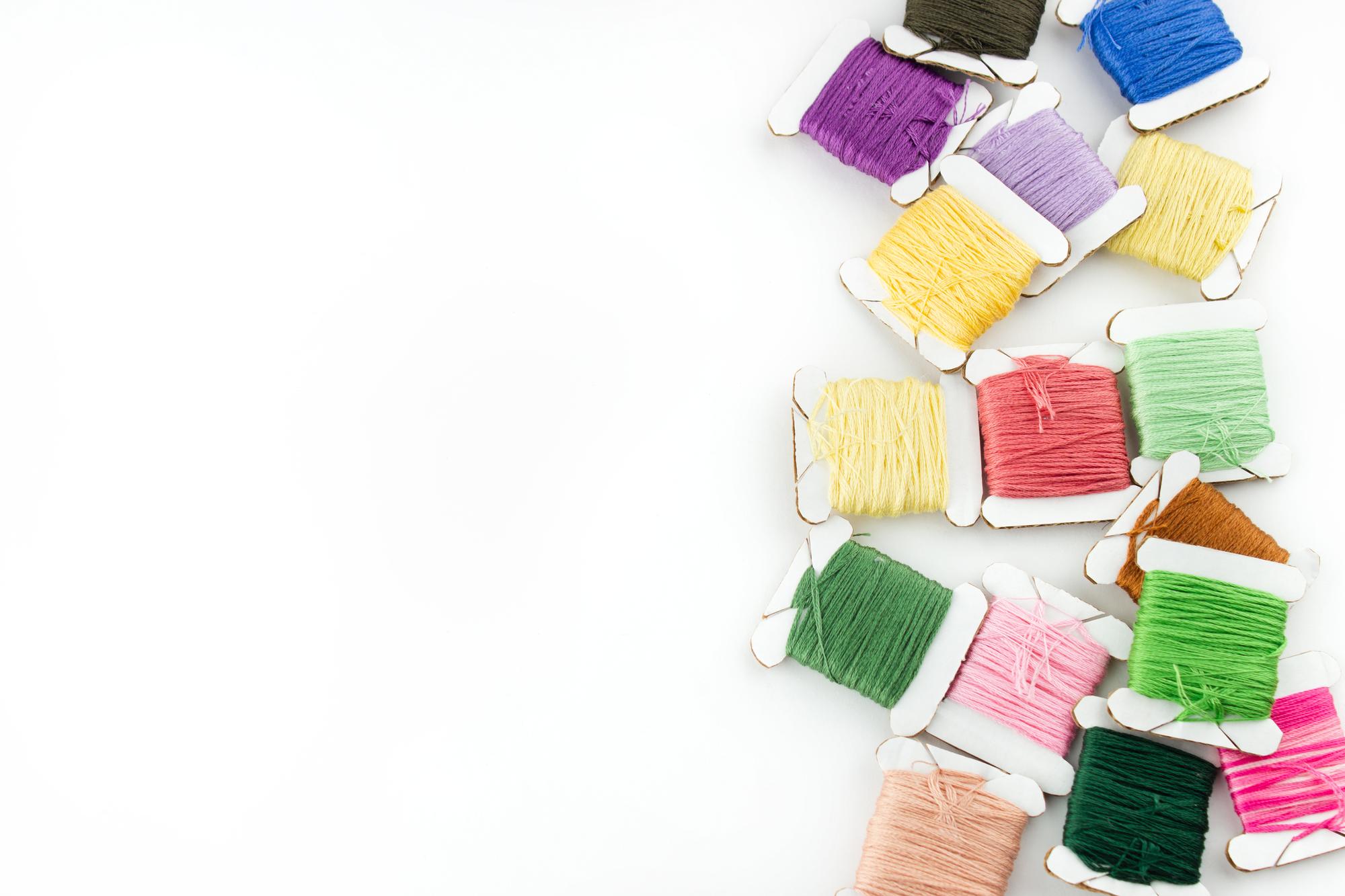 Close up of colored threads on wooden table